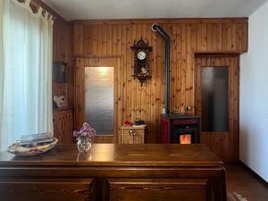 a wooden room with a table and a clock on the wall at Ceda Ladina in Santo Stefano di Cadore