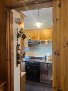 a kitchen with wooden cabinets and a stove top oven at Ceda Ladina in Santo Stefano di Cadore +10 photos