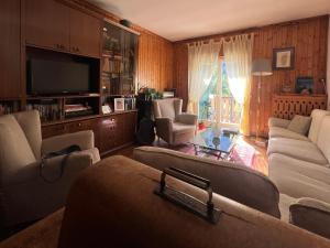 a living room with couches and a flat screen tv at Ceda Ladina in Santo Stefano di Cadore
