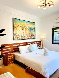 a bedroom with two beds and a painting on the wall at Who's Gloria in El Nido