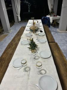 a long table with white plates and wine glasses at el sueño in Las Compuertas