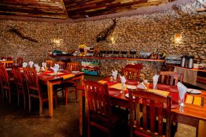 a restaurant with wooden tables and chairs in a room at Hlane Royal National Park in Simunye +83 photos