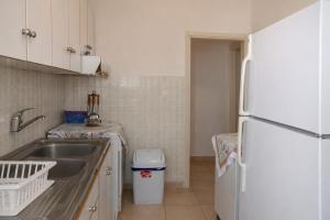 a kitchen with a sink and a white refrigerator at Beachfront Absolute Bliss in Perigiali, Korinthia in Periyiálion +1 photo