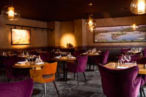 a dining room with tables and purple chairs at Hôtel Daria-I Nor by Les Etincelles in L'Alpe-d'Huez