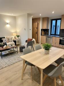 a kitchen and living room with a wooden table and chairs at Sandstone in Noisy-sur-École