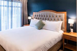 a bedroom with a large white bed and a window at Premier Express Inn George in George