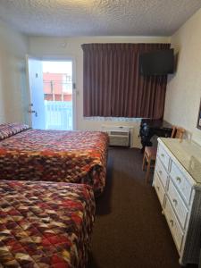 a hotel room with a bed and a desk and a window at Fountain Motel in Wildwood +41 photos