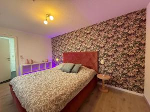 a bedroom with a bed with a purple accent wall at Chez JAJA in Malmedy