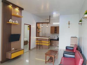 a living room and kitchen with a couch and a table at Thyesza Hotel Resort in Ambarita
