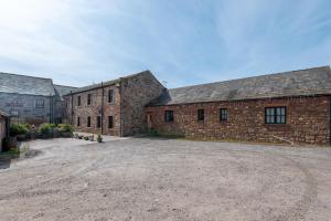 an old brick building with a large driveway at Sandfordarms in Appleby