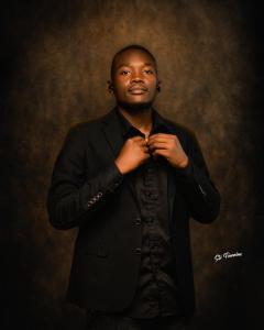 a man in a suit tying his tie at Fournine Media in Mulanje