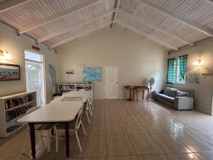 a large living room with a table and a couch at Soufriere Guesthouse in Soufrière