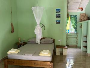 a bedroom with a bed with a net at Soufriere Guesthouse in Soufrière