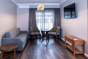 a living room with a couch and chairs and a table at Premier Express Inn George in George +79 photos