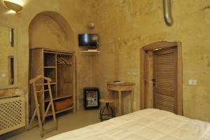 a bedroom with a bed and a tv on the wall at L'Hotel In Pietra in Matera