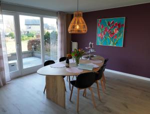 a dining room with a table with chairs and a painting at De Sas in Lisse in Lisse