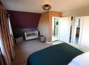 a bedroom with a bed and a room with a crib at De Sas in Lisse in Lisse