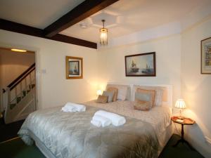 a bedroom with a bed with two pillows on it at Swiss Cottage in Chideock