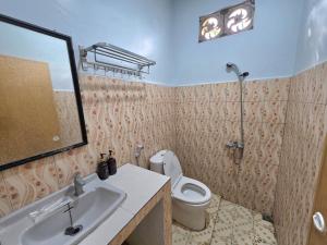 a bathroom with a sink and a toilet and a shower at Thyesza Hotel Resort in Ambarita +27 photos