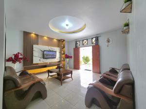 a living room with couches and a flat screen tv at Thyesza Hotel Resort in Ambarita