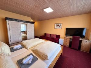 a bedroom with two beds and a flat screen tv at Eiscafé - Pizzeria Antonio in Lichtenau