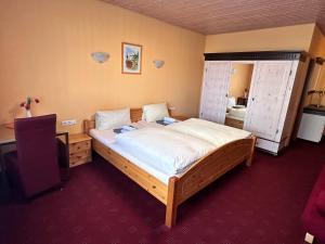 a bedroom with a bed and a desk and a mirror at Eiscafé - Pizzeria Antonio in Lichtenau