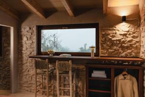 a room with a stone wall with a counter and a window at Habitació EL GRANER in Rasquera