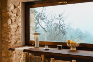 a window with a bowl of fruit on a table at Habitació EL GRANER in Rasquera