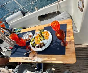 a table with a plate of food on a boat at Casa Veleiro SHALOM in Ponta Delgada