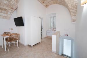 a living room with a table and a tv on a wall at Filo Rosso in Ostuni