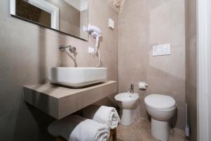 a bathroom with a sink and a toilet at Filo Rosso in Ostuni +38 photos