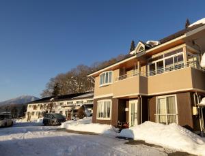 a building with snow in front of it at Elan Villa Nojiri in Shinano