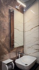 a bathroom with a white sink and a mirror at CozyKey Kalina in Mumbai