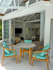 a living room with a table and chairs at Tabu in La Digue