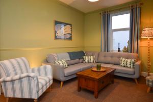a living room with a couch and two chairs and a table at Dunmore Argyll House in Dunoon