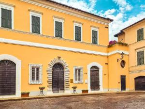 a yellow building with black doors and windows at I Segreti del Borgo - Cosmopolitan in Ostra
