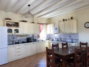 a kitchen with white cabinets and a table with chairs at To Diko Mas House in Stení