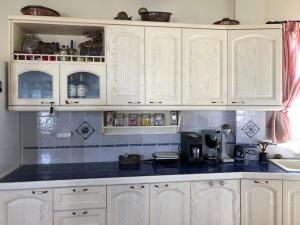 a kitchen with white cabinets and a blue counter top at To Diko Mas House in Stení