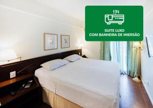 a bedroom with a bed and a green sign at Hotel Nacional Inn Cambuí Campinas Residence in Campinas