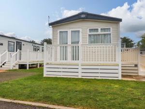 a small house with a white fence in a yard at Coastal Escape in Par