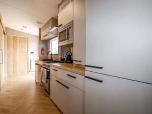 a kitchen with white cabinets and a stove at Coastal Escape in Par