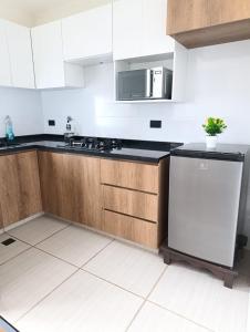 a kitchen with wooden cabinets and a white refrigerator at Ebenezer in Cochabamba