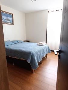 a bedroom with a bed with a blue blanket at Ebenezer in Cochabamba