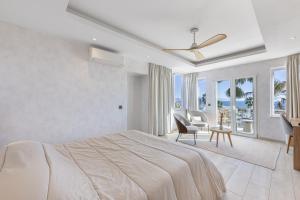 a white bedroom with a bed and a table and chairs at Stunning 5-Bed Villa with Private Pool in Manilva +88 photos