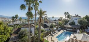 an aerial view of a house with a swimming pool and palm trees at Stunning 5-Bed Villa with Private Pool in Manilva