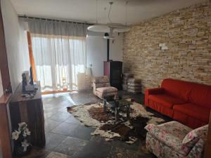 a living room with a red couch and a brick wall at Casa Castellina in Bettolle