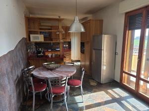a kitchen with a table with chairs and a refrigerator at Casa Castellina in Bettolle
