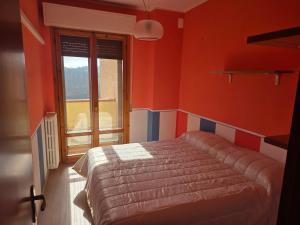 a bedroom with red walls and a bed with a window at Casa Castellina in Bettolle
