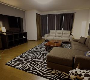 a living room with a couch and a table at Elan Villa Nojiri in Shinano