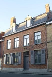 un bâtiment en briques rouges avec une porte dans une rue dans l'établissement Guesthouse Recour, à Poperinge